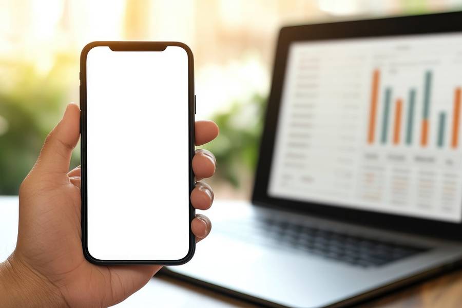 Social Media Marketing Hand Holding A Smartphone Next To A Laptop Showing Social Media Engagement Analytics Charts